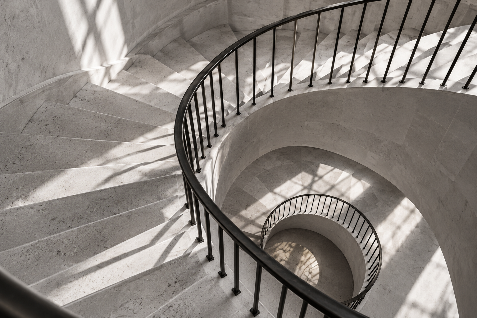 Sculptural limestone staircase seen from above, revealing the architecture beneath the experience